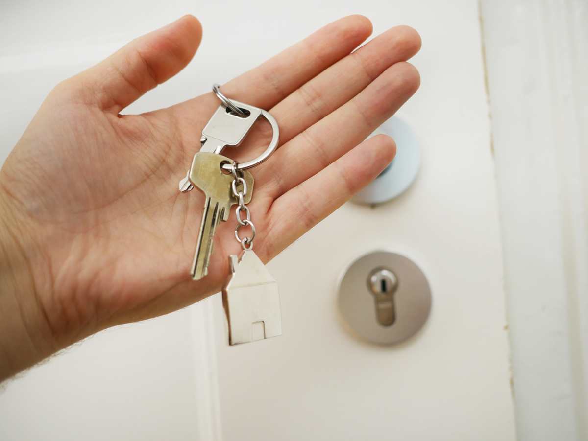 person-holding-house-keys-in-front-of-a-door-lock
