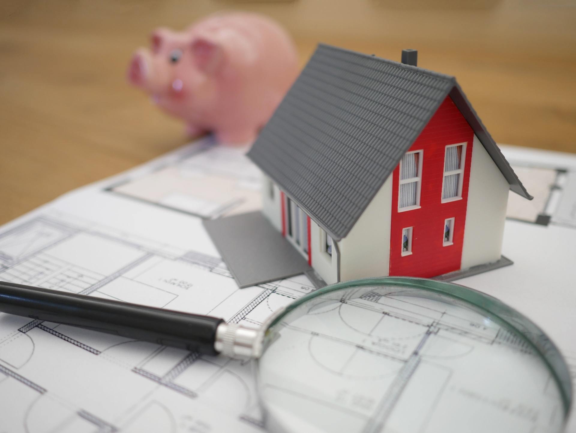 property-plan-with-magnifying-glass-and-piggy-bank